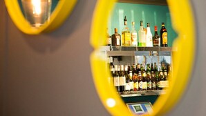 A bar area with shelves of various liquor bottles. - ibis Styles Geraldton (Tarcoola Beach)