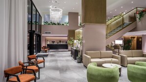 A spacious lobby with a reception desk, seating areas, and a staircase. - DoubleTree by Hilton Laredo (Laredo)