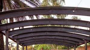 A covered walkway with a person walking away from the camera. - The Lodge Motel, Newman (Newman)