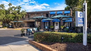 A Best Western hotel with outdoor seating and umbrellas.