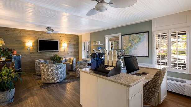 A modern kitchen with a built-in island, a flat-screen TV, and a coffee station.