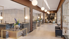 A hotel lobby with marble reception counters, seating areas, and a fireplace. - Hilton Munich City (Munich)