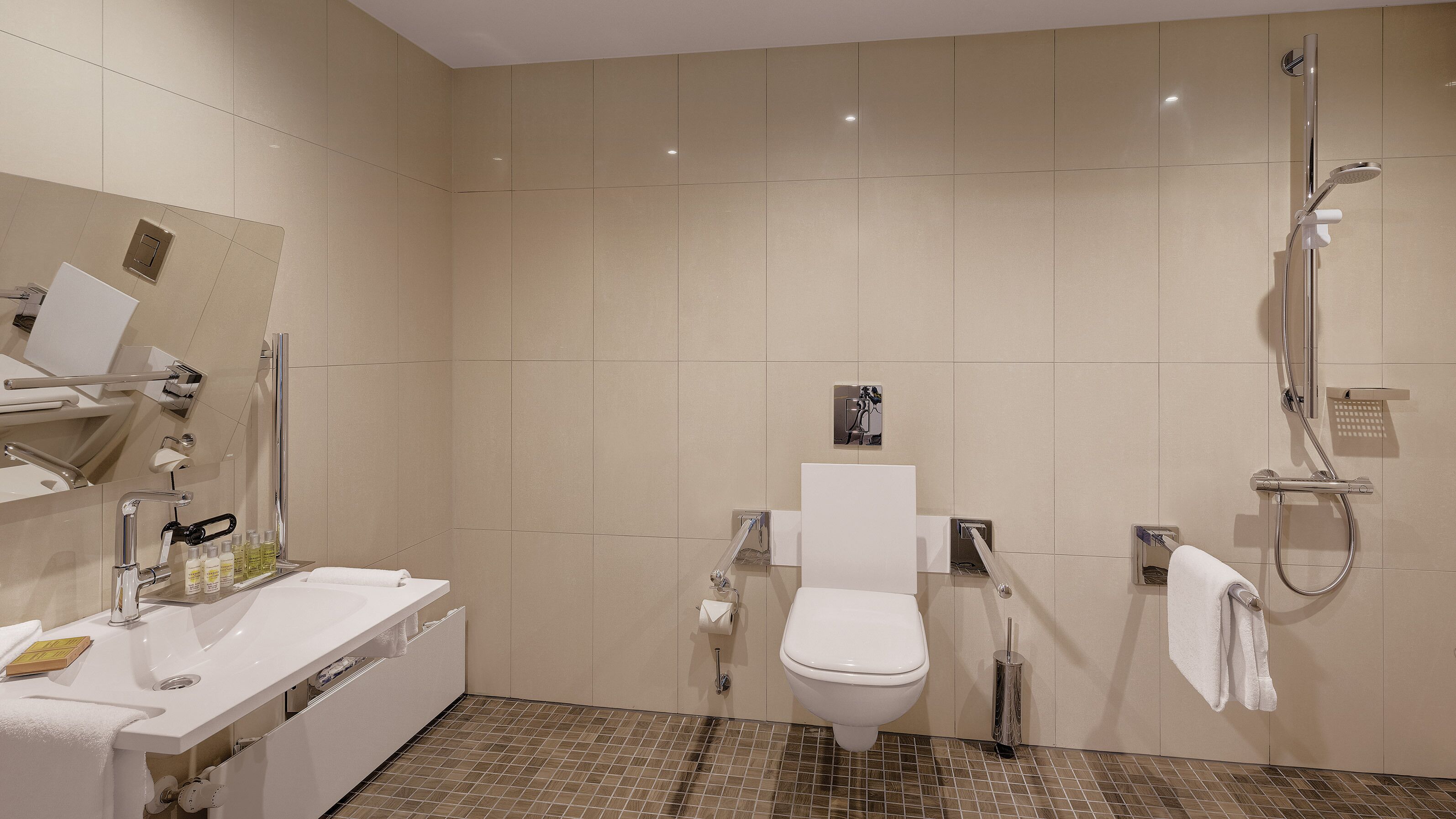 A modern bathroom with a white sink, toilet, and shower.