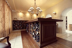 A wine cellar with wooden shelves and a central bar area.
