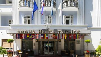 L’entrée du Grand Hôtel Toplice, avec ses nombreux drapeaux, son tapis rouge et ses espaces de repos en plein air.