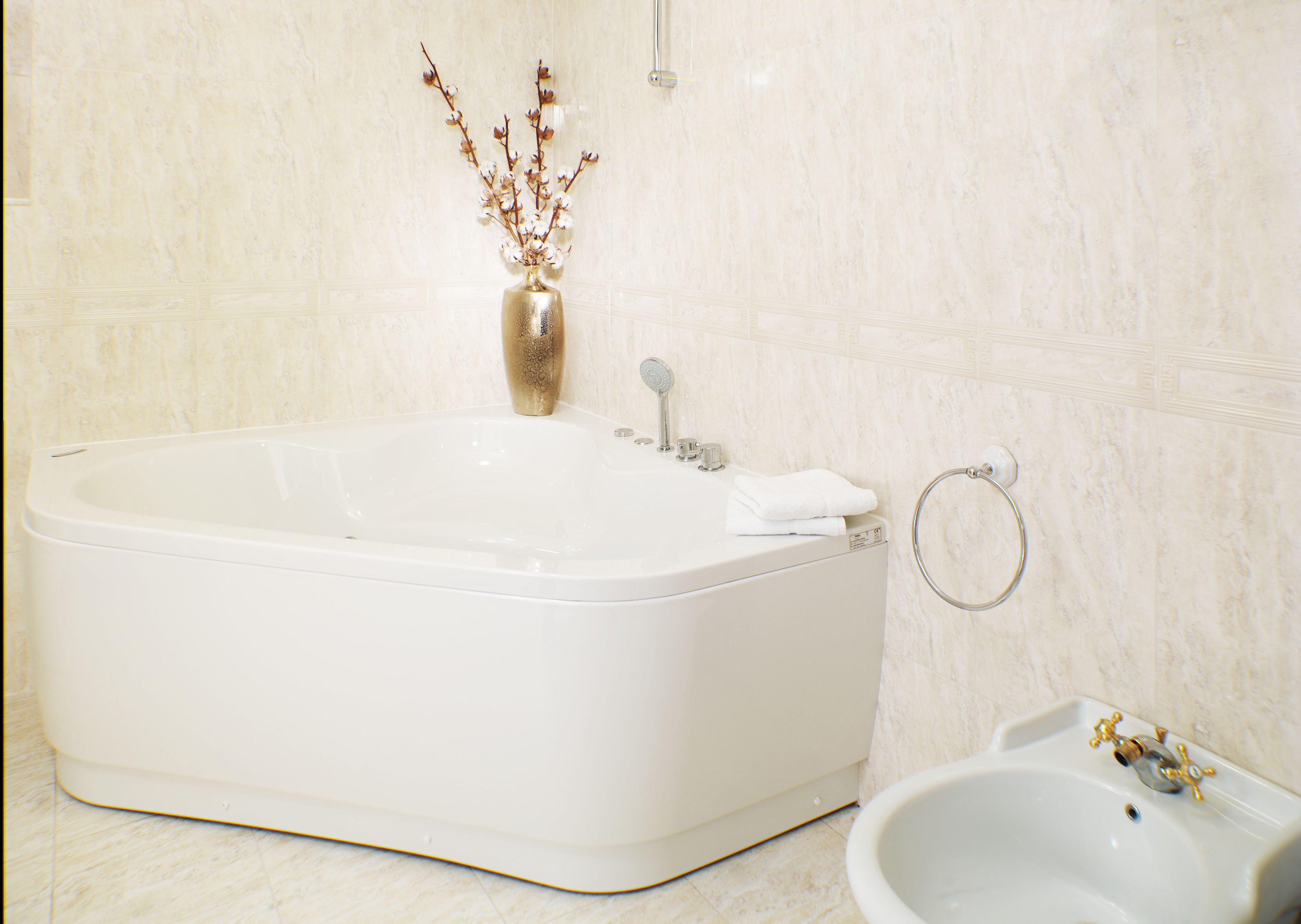 A modern bathroom with a freestanding bathtub, a sink, and a towel rack.