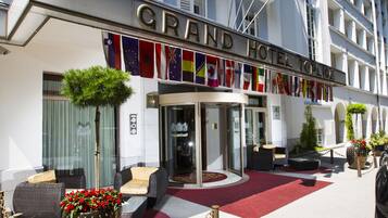 Un hôtel doté d’une entrée imposante, de nombreux balcons et de drapeaux de différents pays.