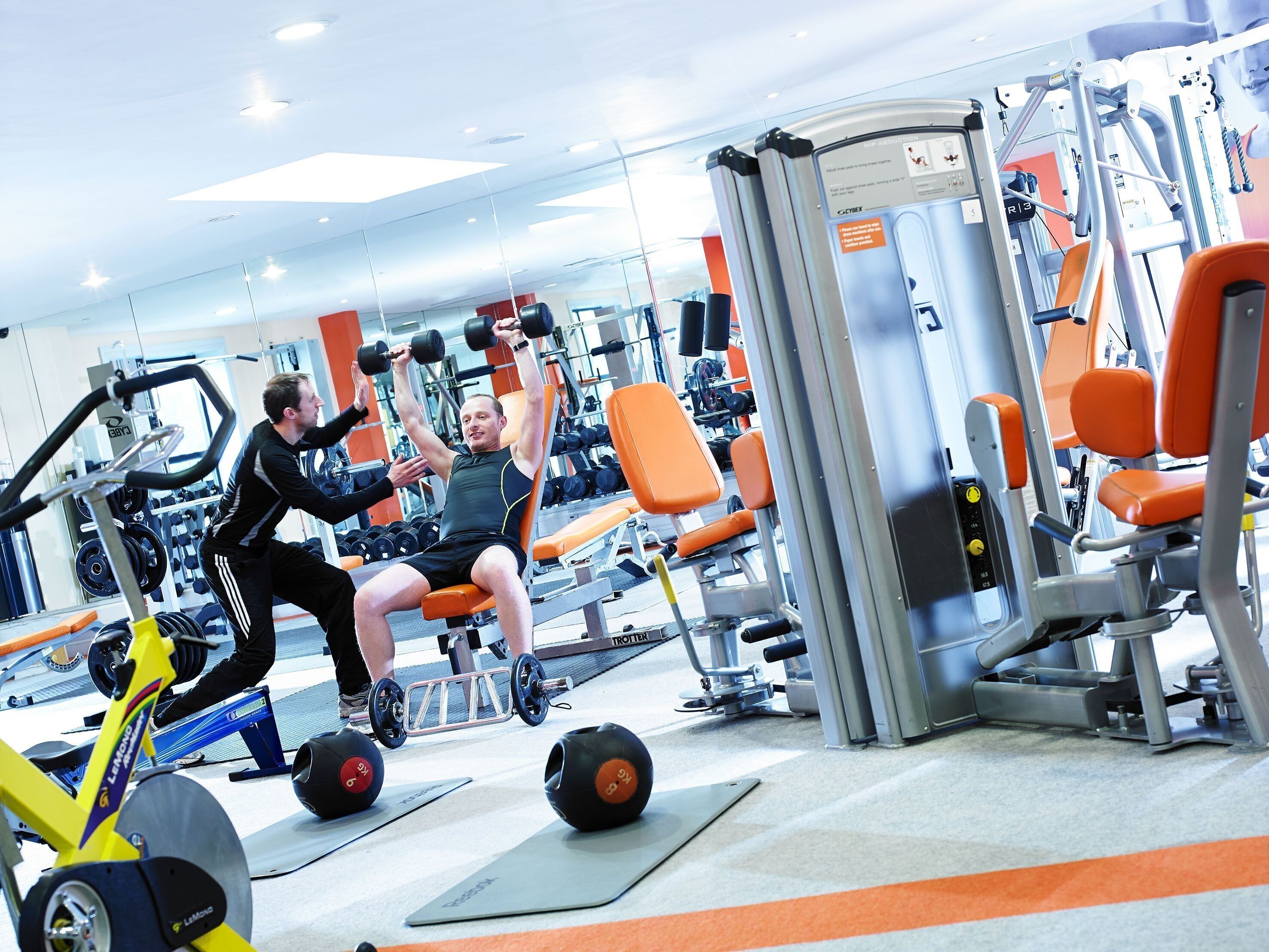 A gym with exercise equipment, including a rowing machine and weight benches.