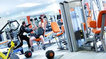 A gym with exercise equipment, including a rowing machine and weight benches.
