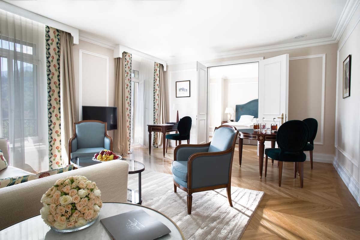Una sala de estar amplia con sofá, sillones, una mesa de centro y un comedor con sillas y una mesa.