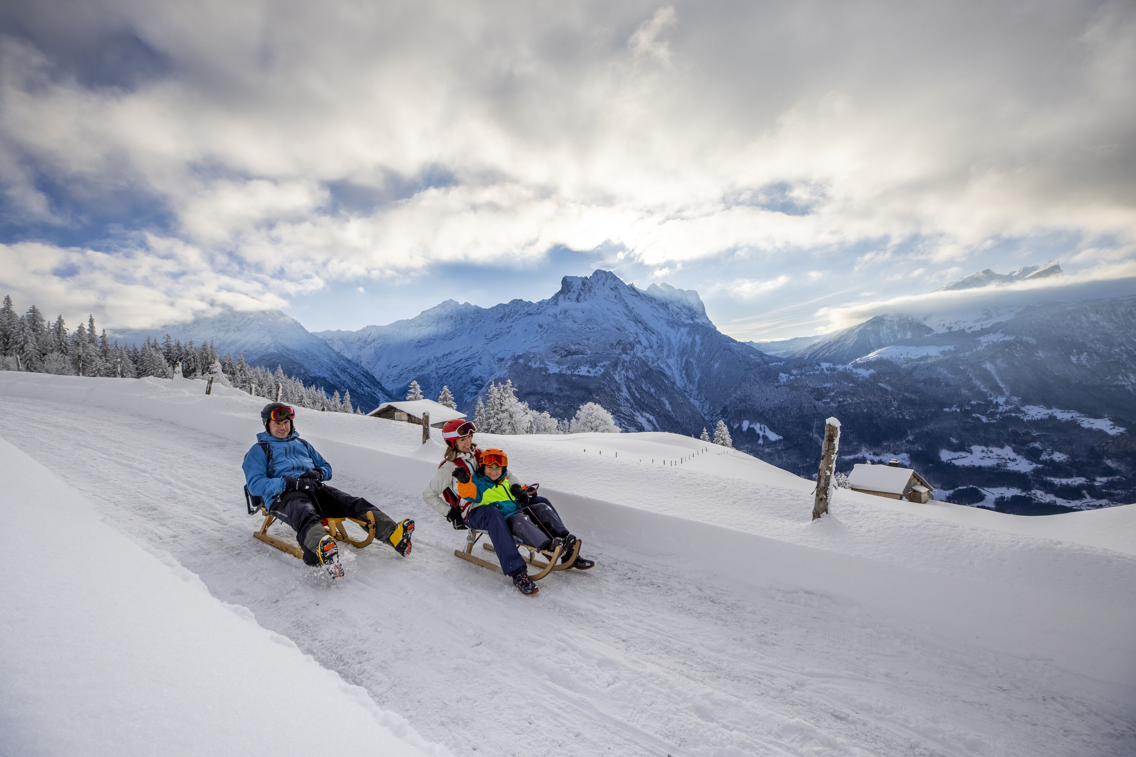 Une pente de montagne enneigée avec une piste en bois pour la luge.
