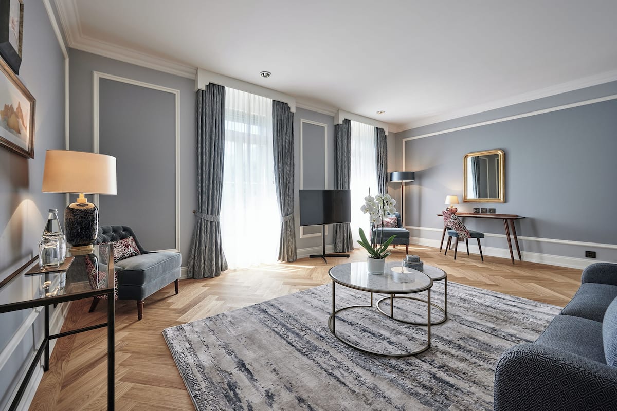 Una sala de estar moderna con sofá, mesa de centro, televisor y comedor con mesa y sillas.