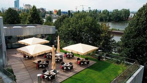 A rooftop terrace with outdoor seating and a view of the city skyline. - Delta Hotels by Marriott Frankfurt Offenbach (Offenbach am Main)
