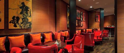 A restaurant with red seating, wooden walls, and artwork.
