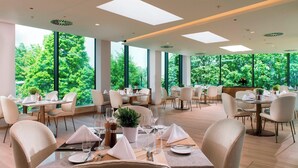 A spacious dining area with high ceilings, large windows, and modern furnishings. - Delta Hotels by Marriott Frankfurt Offenbach (Offenbach am Main)