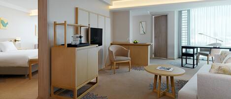 Une chambre d’hôtel comprenant un lit, un bureau, une chaise, un canapé et une petite table.
