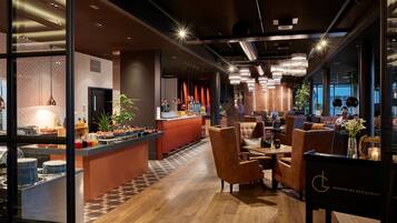 A modern restaurant interior with a bar area, seating, and a visible menu board.