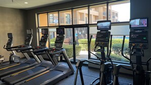 A gym with treadmills, elliptical machines, and a rowing machine. - Courtyard by Marriott Dallas Northwest (Dallas)