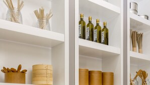 A white shelving unit with various storage containers and kitchen utensils.