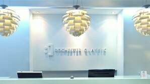 A reception desk with three hanging lamps and a sign reading "ROCHESTER CLASSIC".