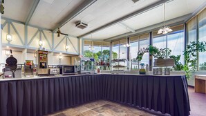 A buffet setup with a long table, food display, and seating area. - Hospitality Inn (North Platte)