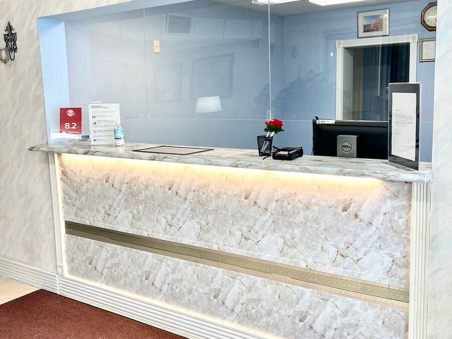 A reception desk with a marble counter, a clock, and a framed picture on the wall.