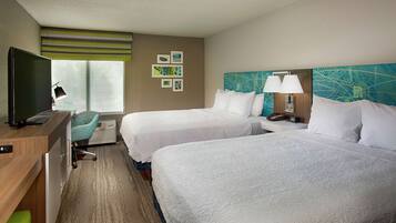 A hotel room with two beds, a desk with a computer, a chair, and a TV.