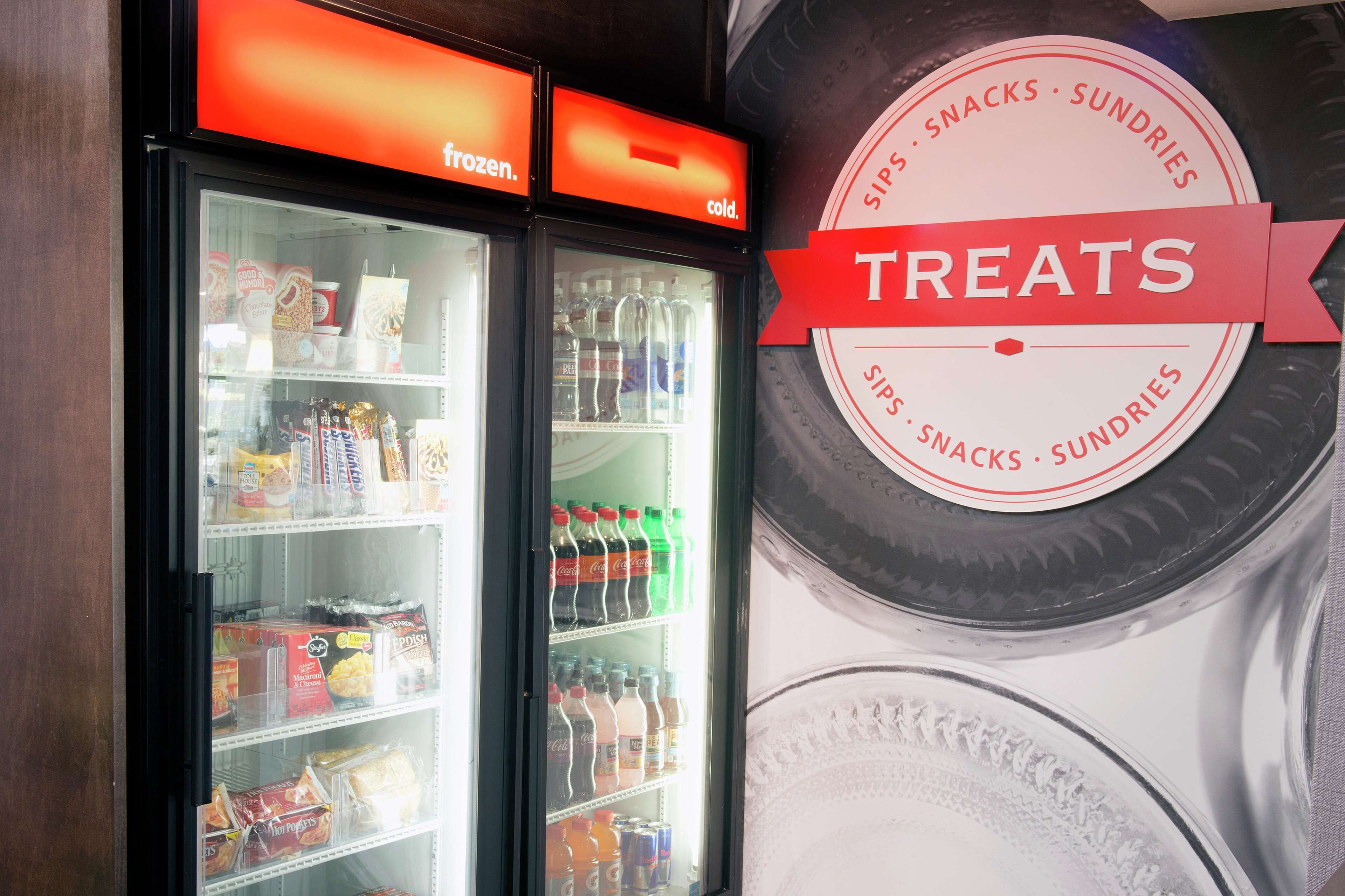 Une vitrine réfrigérée portant l’inscription « EN-CAS », dans laquelle sont présentés divers produits et boissons.