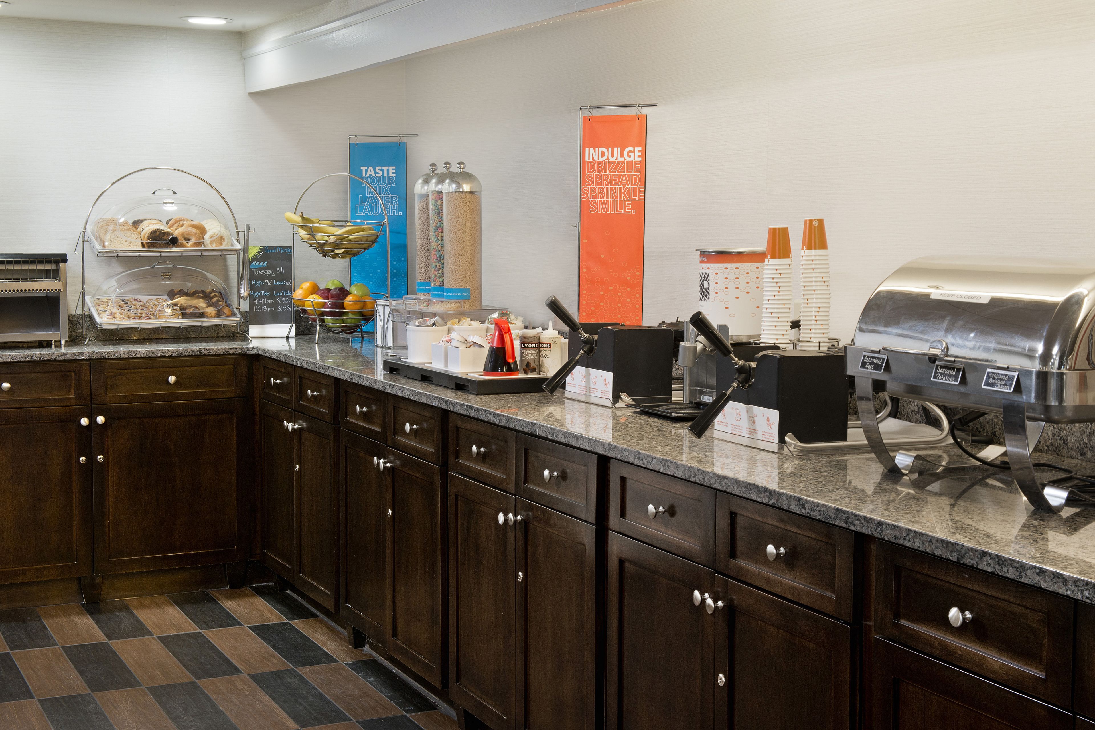Een buffetopstelling met diverse gerechten, een drankstation en een grill.