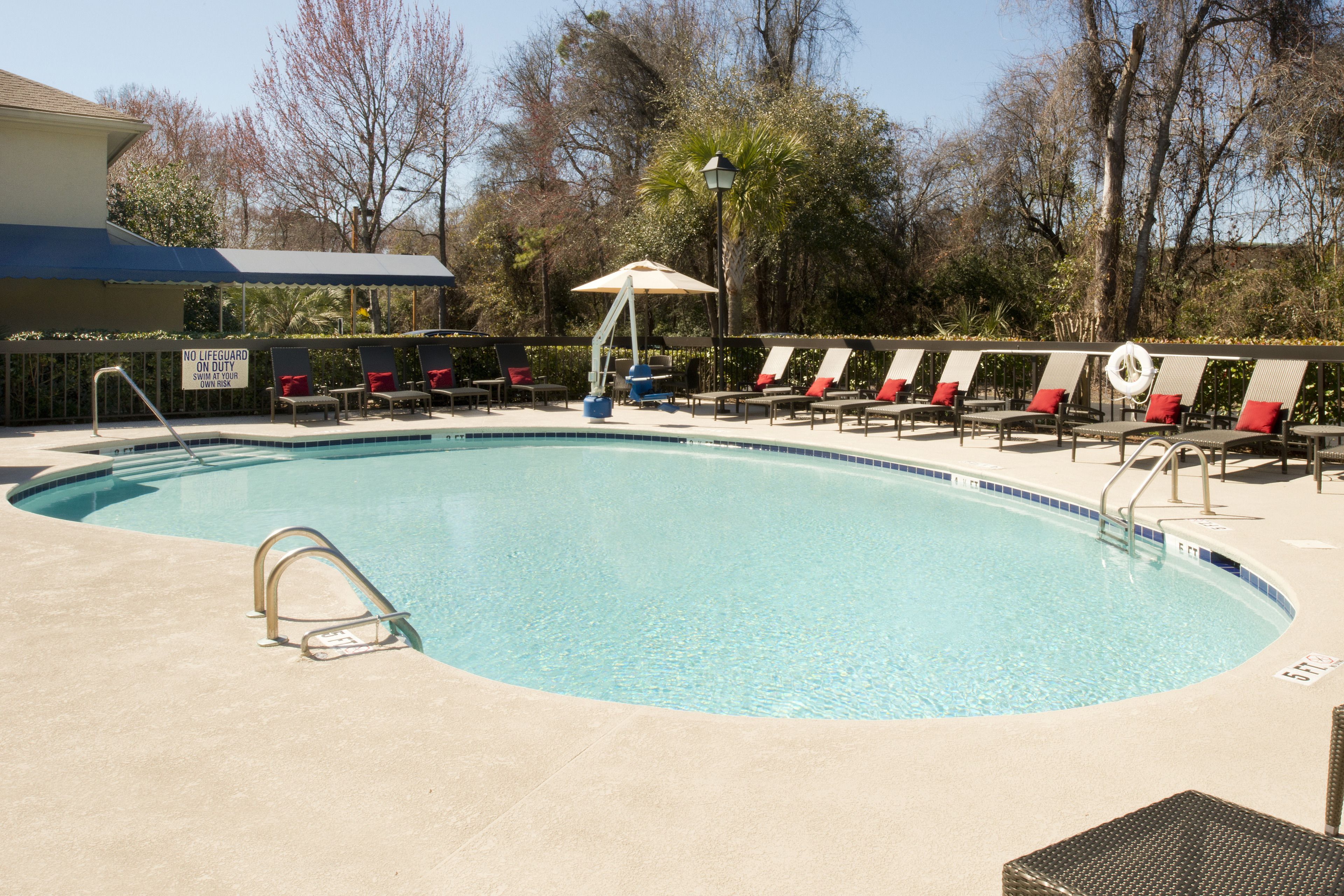 A swimming pool with lounge chairs and a lifeguard stand.
