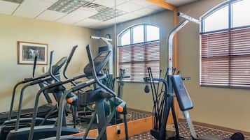 A gym with treadmills, elliptical machines, and weight equipment.