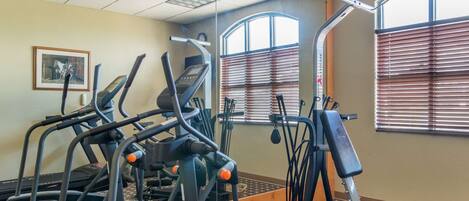 A gym with treadmills, elliptical machines, and weight equipment.
