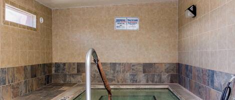 Une piscine avec un panneau indiquant une profondeur de 3 pieds et un avertissement interdisant de plonger.