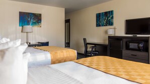 A hotel room with two beds, a desk, a chair, a TV, and a microwave.