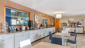Una cocina de hotel con un sistema de bufé, que incluye una estación de café y diferentes alimentos.