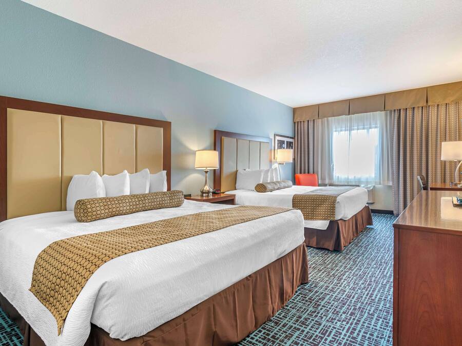 Una habitación de hotel con dos camas, un escritorio y una televisión.