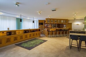 A spacious kitchen with a central island, bar area, and a seating section. - Aspire Frankfurt Airport, Trademark Collection by Wyndham (Ruesselsheim)
