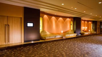 Relax in our welcoming lobby, featuring a long reception desk and comfortable seating areas.