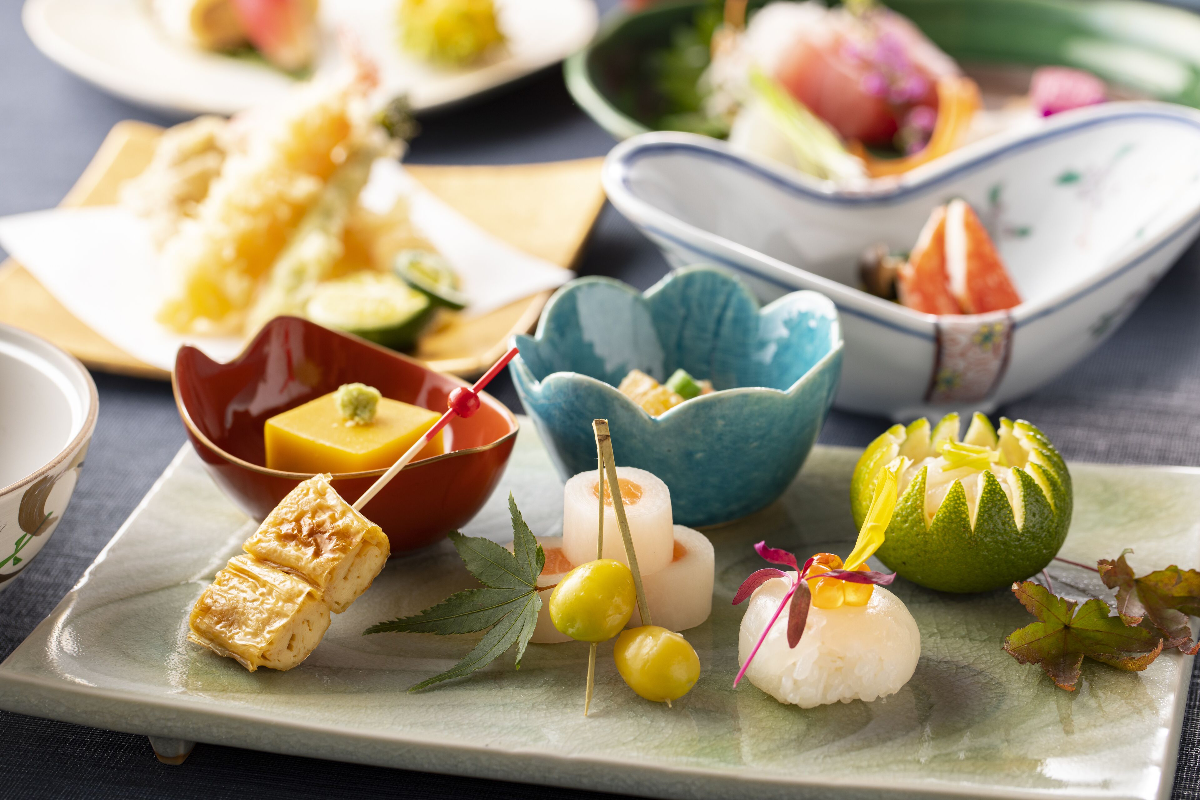 A variety of Japanese dishes on a plate, including sushi and pickled vegetables.