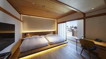 Habitación de hotel moderna con una cama grande, un escritorio y vistas al horizonte de la ciudad.