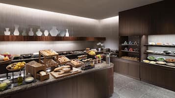 A modern kitchen with a marble countertop, wooden cabinets, and a variety of food items and utensils.