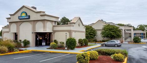 Ein Days Inn Hotel mit Parkplatz und begrünten Außenanlagen.