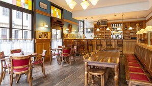 Een restaurant met houten meubels, een bar en uitzicht door grote ramen.