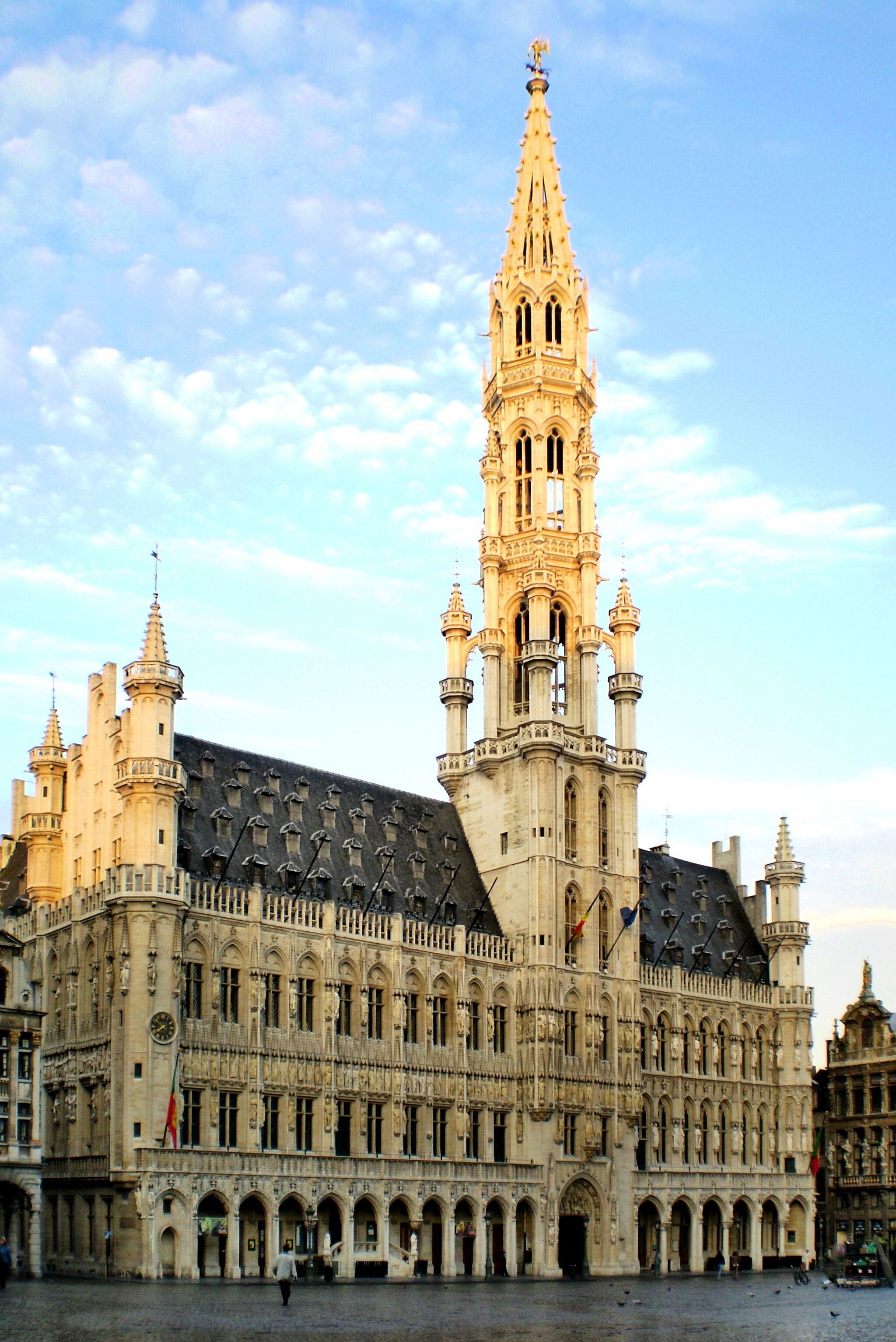 A historic building with a prominent tower, arched windows, and a courtyard.