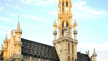 A historic building with a prominent tower, arched windows, and a courtyard.