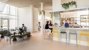 A modern interior with a bar area, seating, and a staircase leading to outdoor space. - Novotel Brugge Centrum (Bruges)