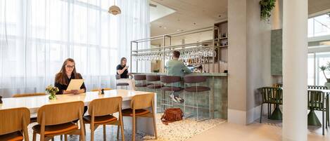A modern interior with a bar area, seating, and large windows.