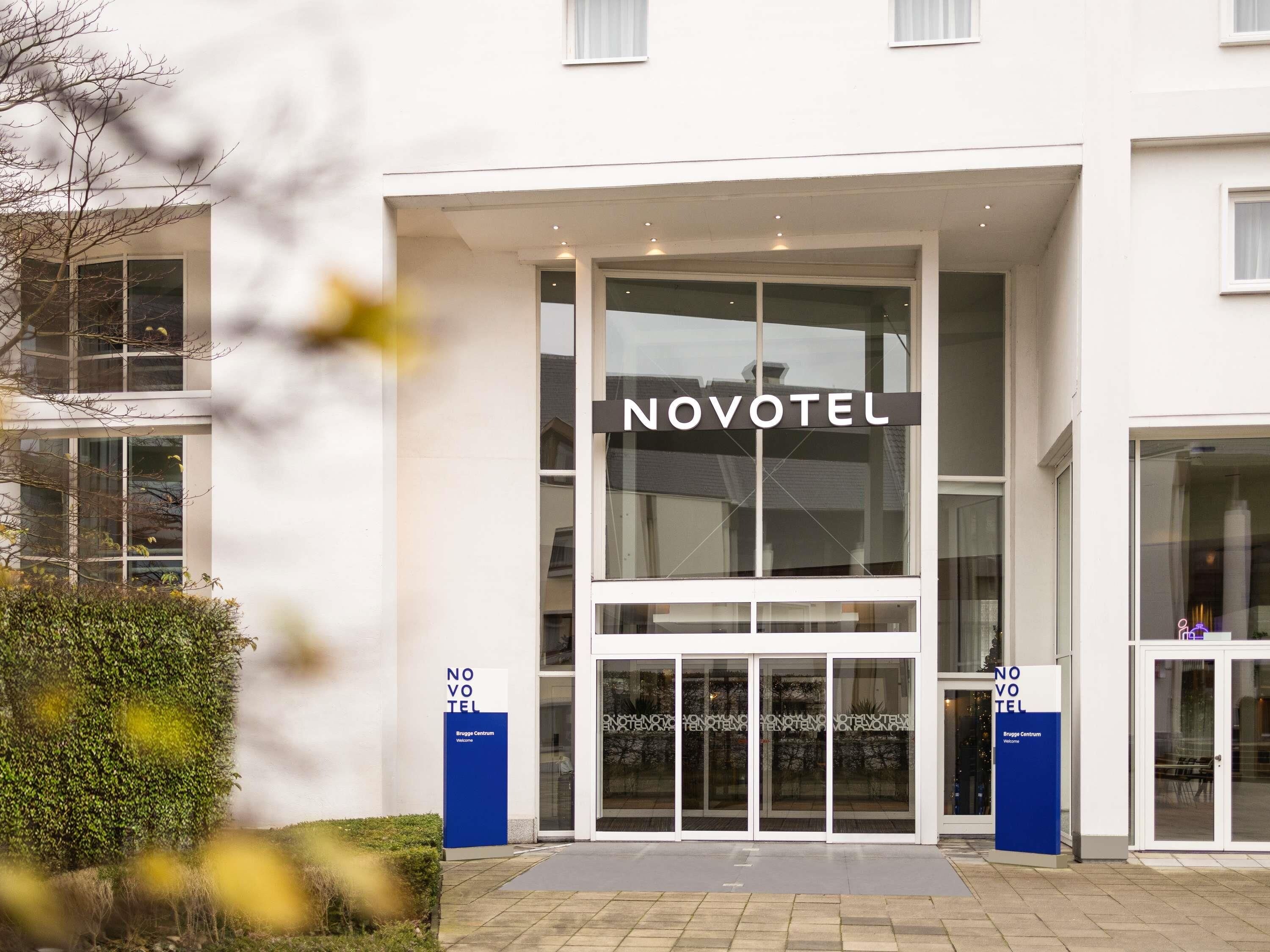 Une entrée d’hôtel moderne avec le nom « NOVOTEL » bien en évidence.