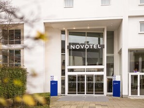 Een moderne hotelentree, met de naam 'NOVOTEL' duidelijk zichtbaar.