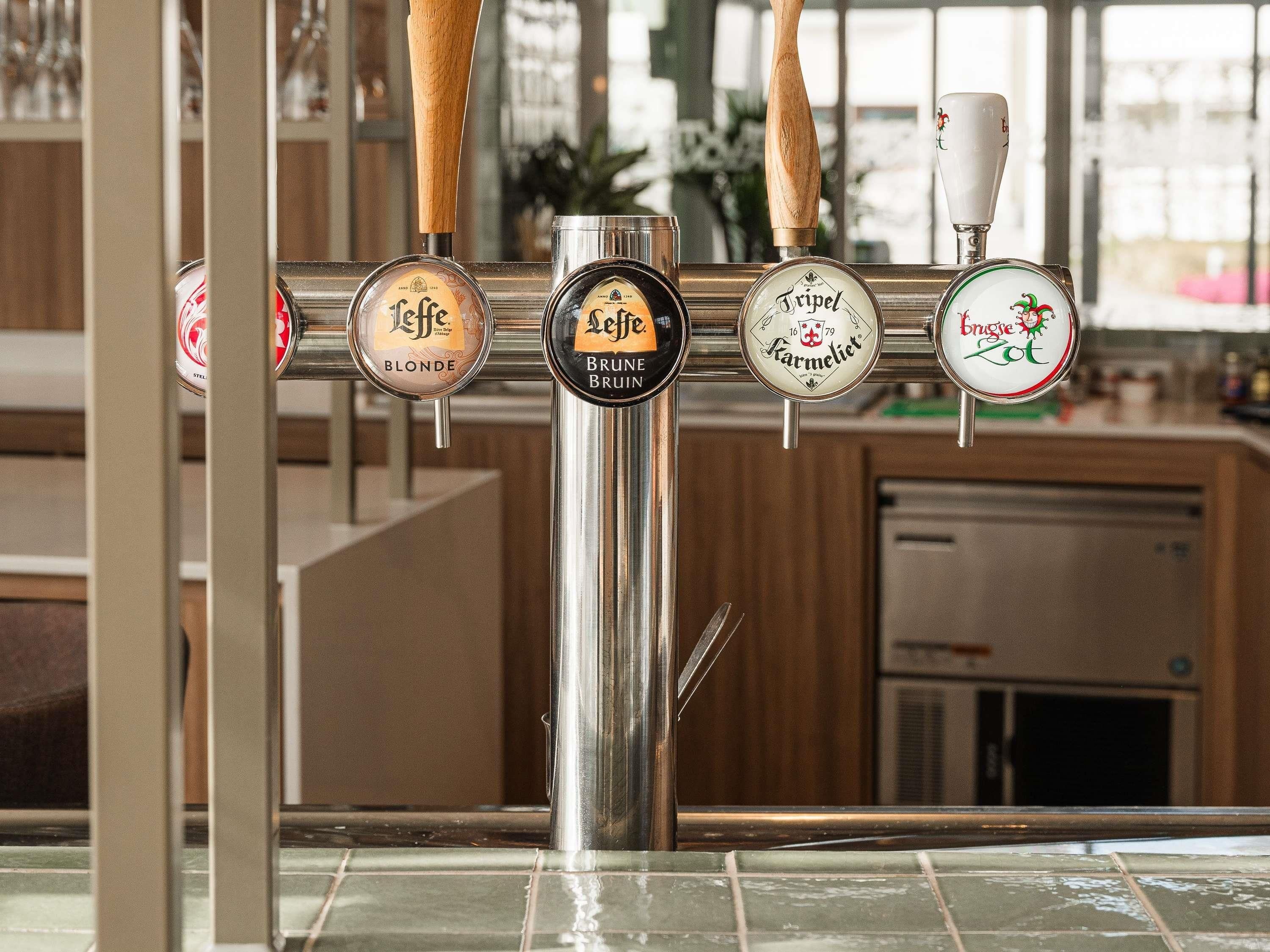 A bar with multiple taps, each labeled with different beer brands.